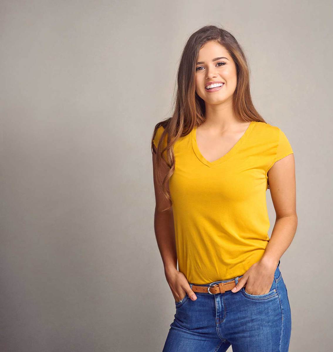 Attractive young woman wearing yellow shirt and jeans