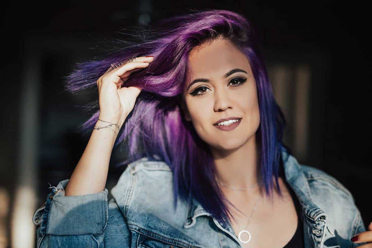 Beautiful girl playing with her purple hair