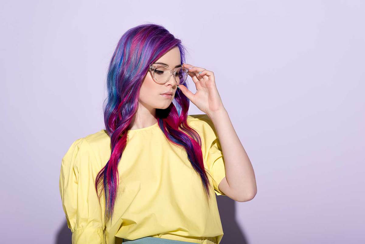 Sensual young woman with colorful hair and stylish eyeglasses