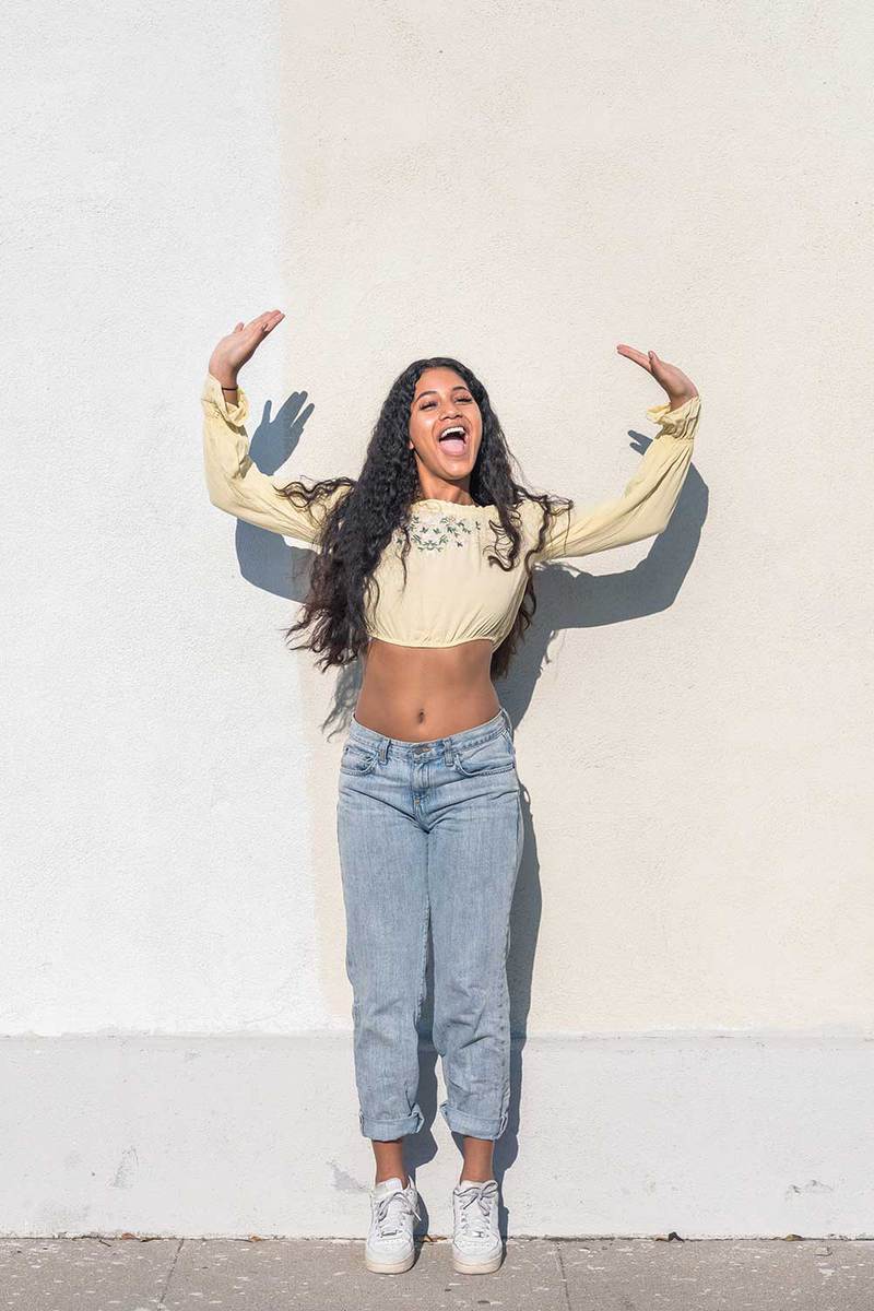 Young millennial black woman wearing a crop top long sleeve blouse and jeans