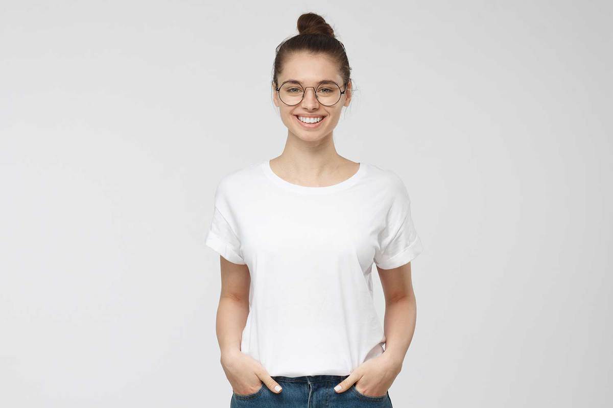Young woman standing with hands in pockets wearing plain white tshirt