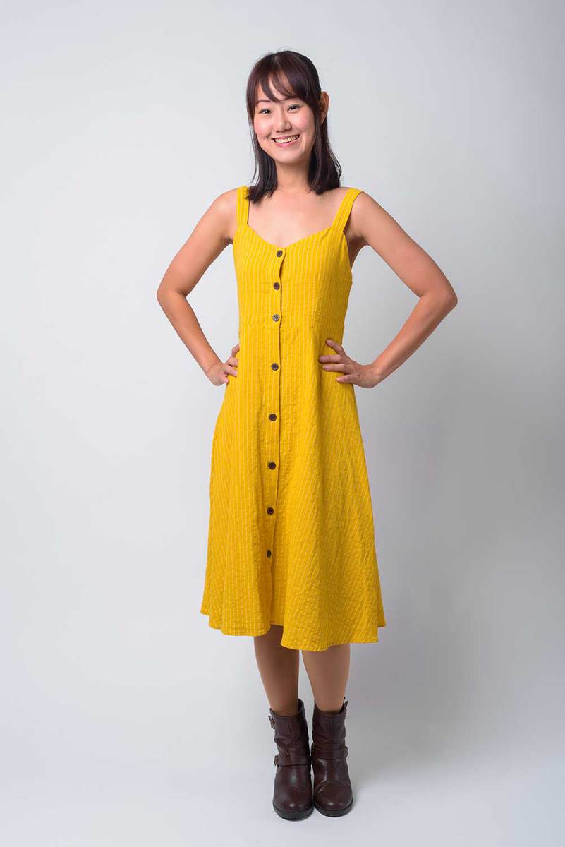 Beautiful asian woman wearing yellow dress and black boots