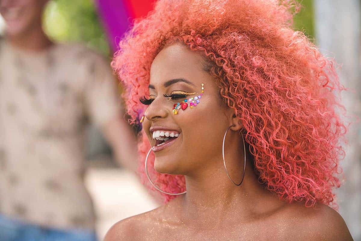 Красивая розоволосая женщина с блестящим макияжем на праздновании карнавала
