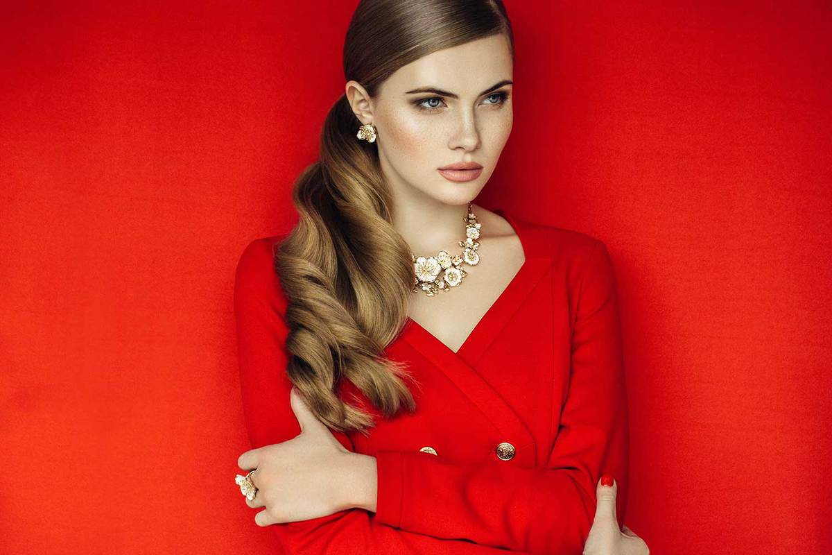 Young fierce beautiful woman in red dress wearing matching necklace and earrings