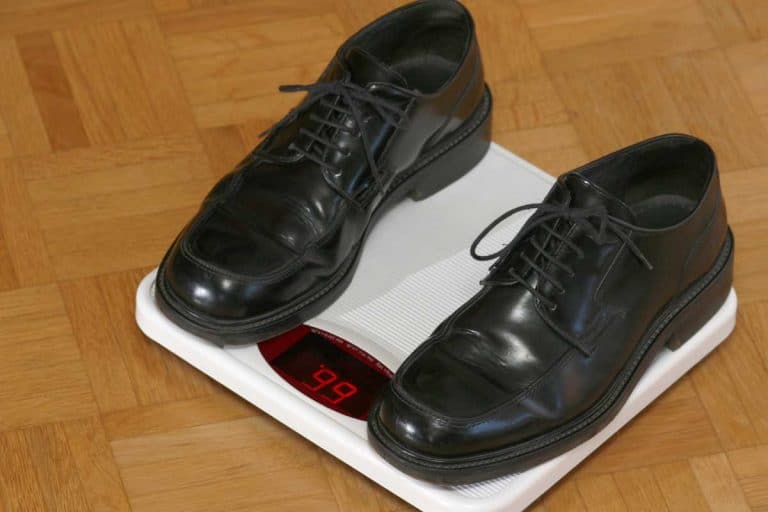 Pair of black shoes on a weighing scale