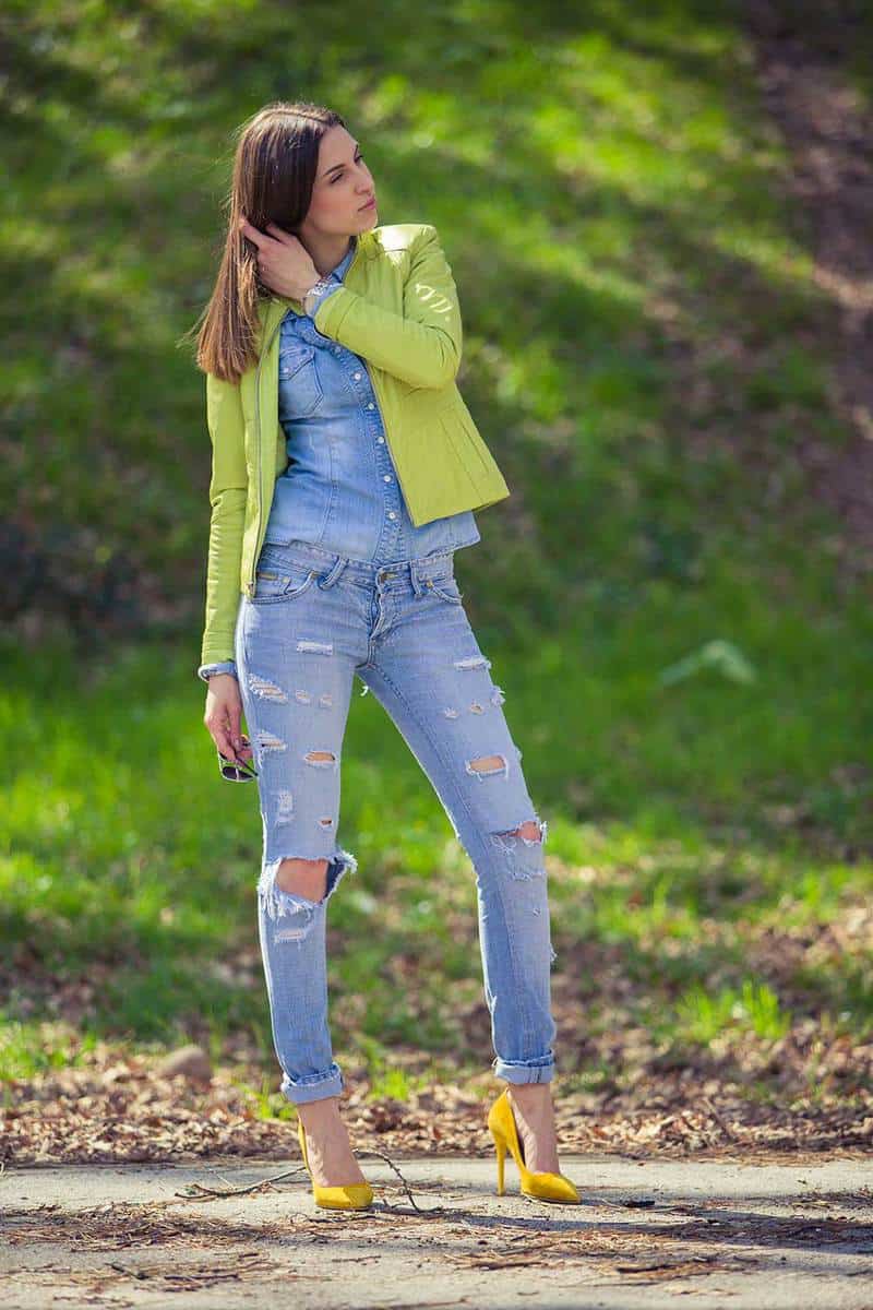 Stylish pretty woman in tattered jeans and yellow heels