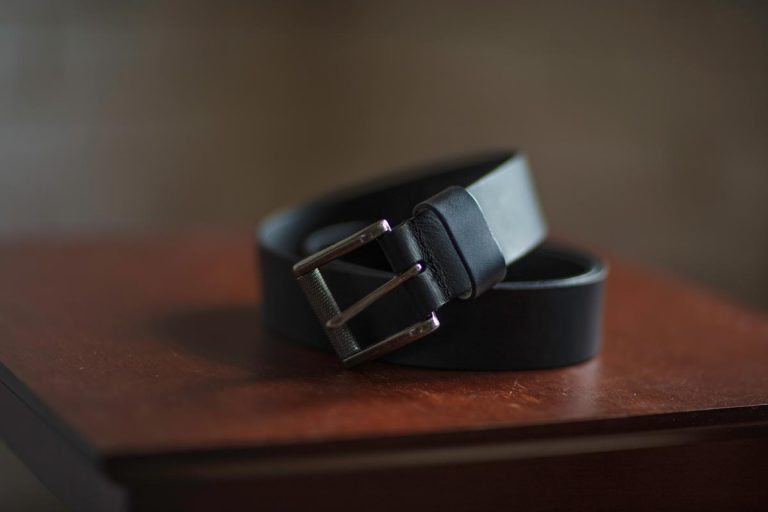 A leather belt placed on a wooden table, How Long Does a Leather Belt Last?