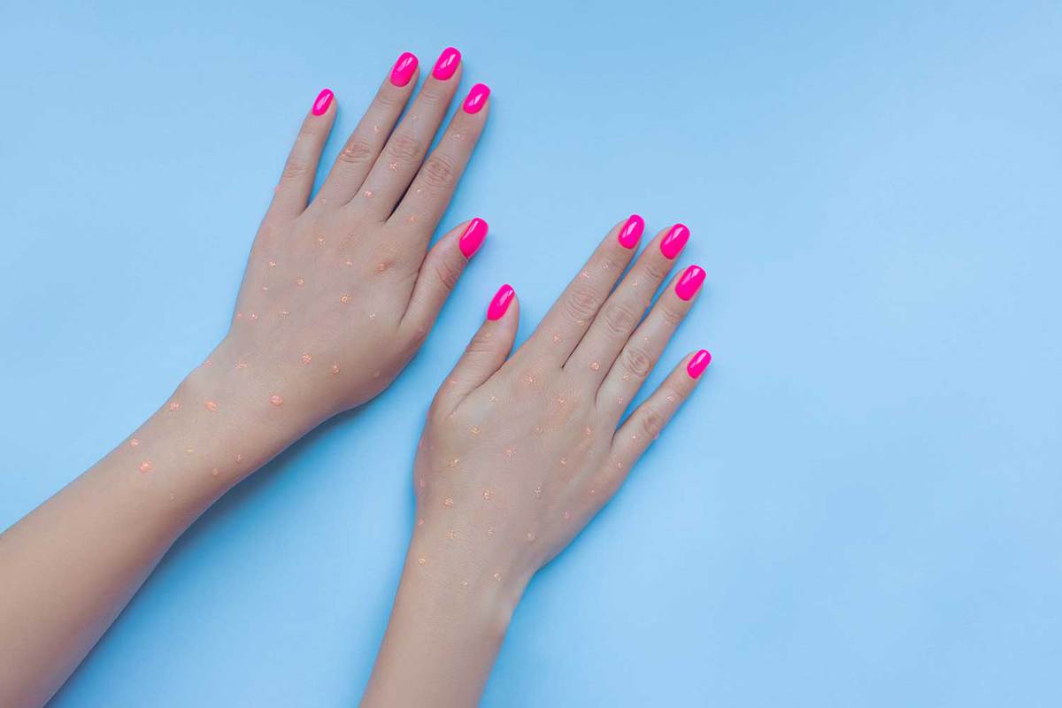 Beautiful neon plastick pink nails on blue background