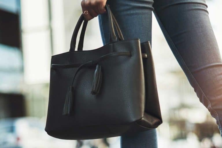 Businesswoman walking with her black handbag in the city, What Color Handbag Goes With EVERYTHING?