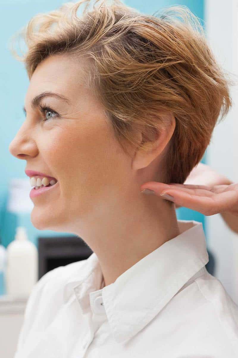 Парикмахер укладывает волосы клиентов на работе