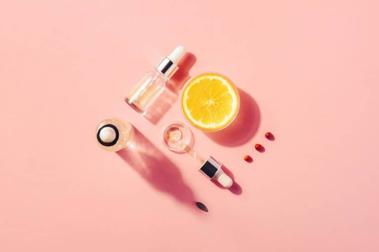 Organic serum with vitamin C placed on a pink surface, How to Use Vitamin C Serum? [Including how when and how often]