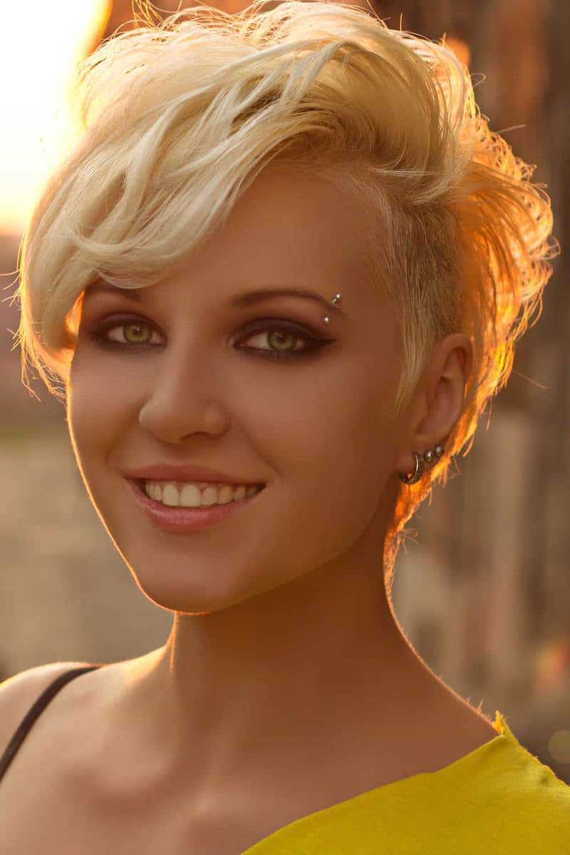 Портрет красивой девушки с короткими волосами, улыбающейся на закате