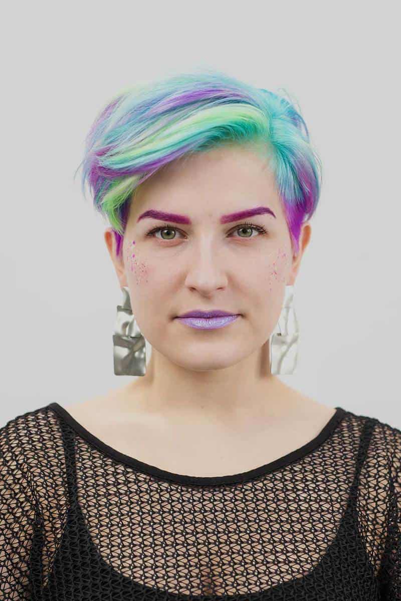 Young beautiful woman with pixie bob short haircut dyed blue and green