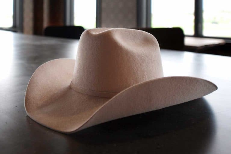 A cowboy hat lays on the bar in a an urban style saloon, How Much Does A Cowboy Hat Cost?