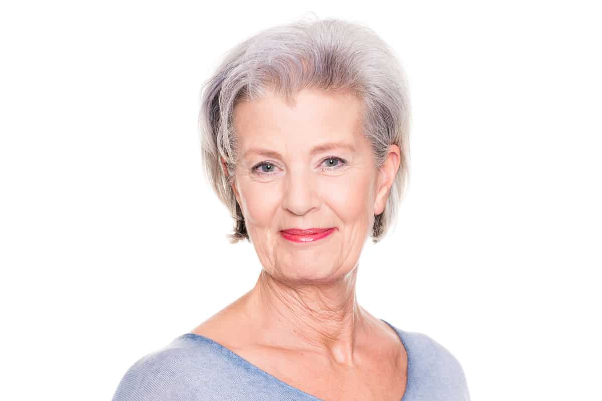 Smiling senior woman in front of a white background