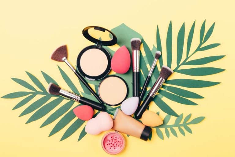 Beauty makeup products and tools including blending brush on palm leaves on yellow background, What Is the Best Blending Brush? [3 Recommendations!]