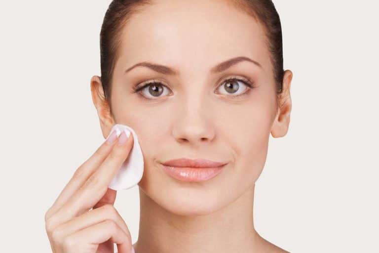 Portrait of a cheerful woman smiling while applying toner on her face, 5 Great Alternatives To Cotton Pads For Toner