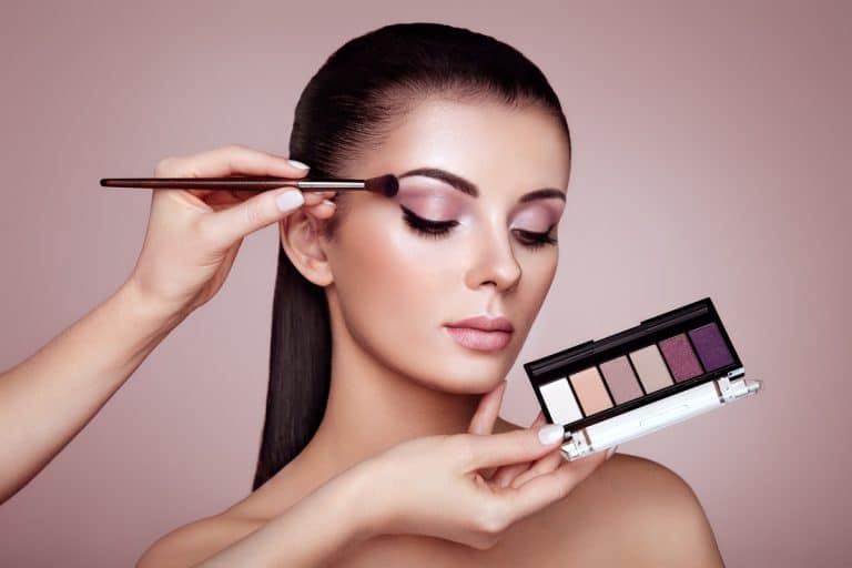 Make up artist applying eyeshadow on her model, Does Eyeliner Go On Before Eyeshadow?