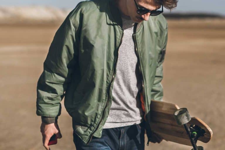 Young rebelious skater with his board, walking alone wearing bomber jacket, Are Bomber Jackets Waterproof?