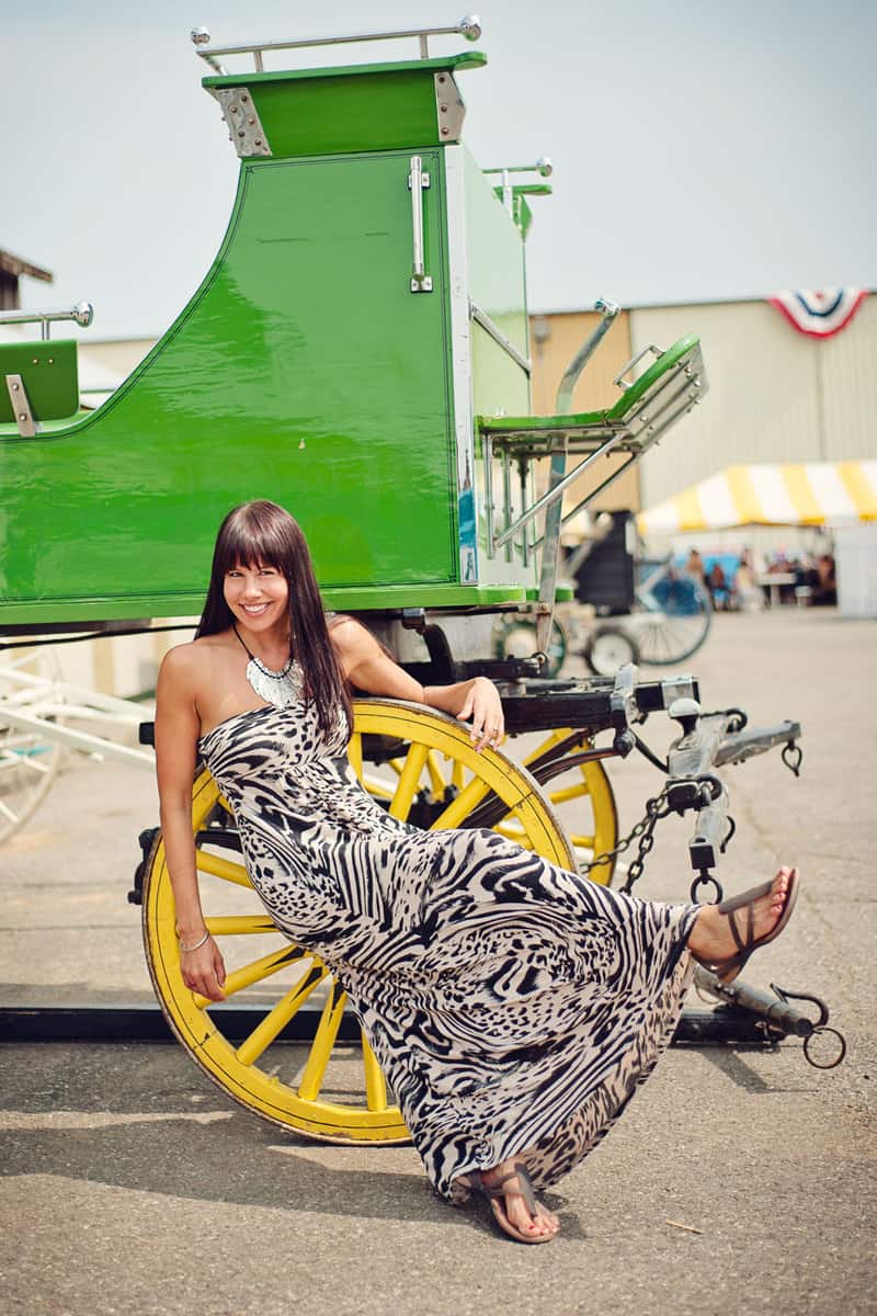 A woman sitting on a wheel wearing a maxi dress