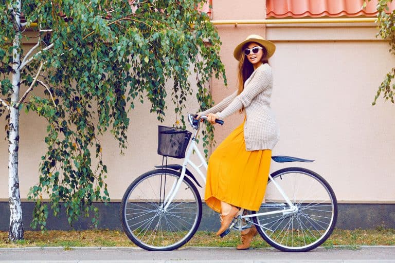 A woman wearing a yellow maxi dress while riding a bike, What Shoes To Wear With Maxi Dresses?