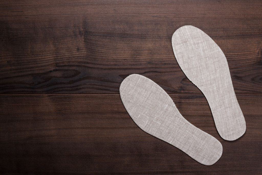 Grey insoles for shoes on wooden background