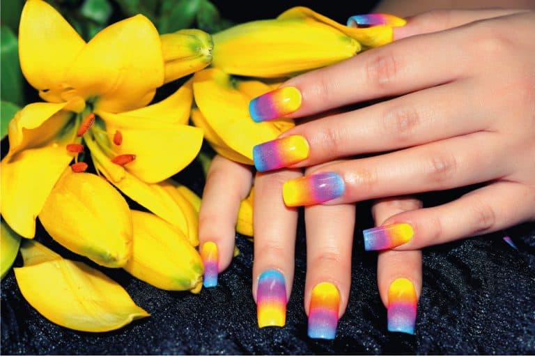 Female hands with colorful nail design holding beautiful yellow flower, What Color Nails With Red Dress?