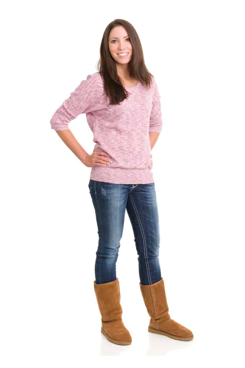 Portrait of a young woman wearing shearling boots on a white background