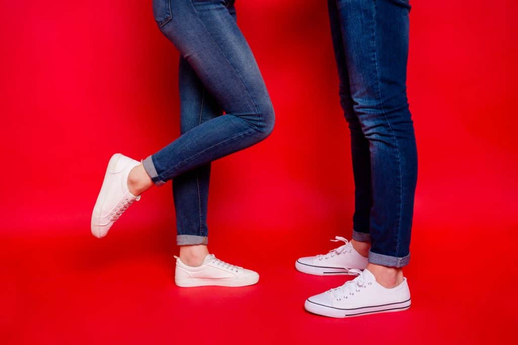 Two couples wearing denim pants and white shoes