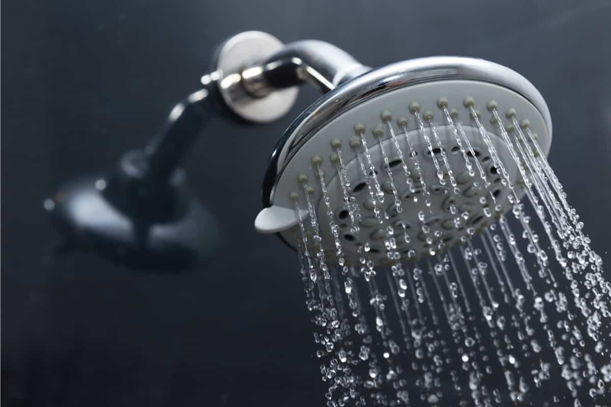 Close up image of a shower head with water emanating from the nozzles
