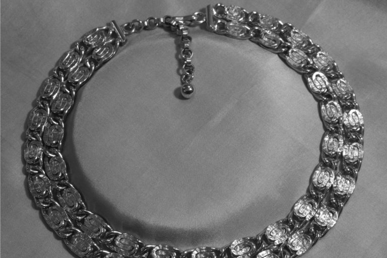 Rhodium plated necklace on a gray silk mat, Does Rhodium Plating Wear Off Jewelry?