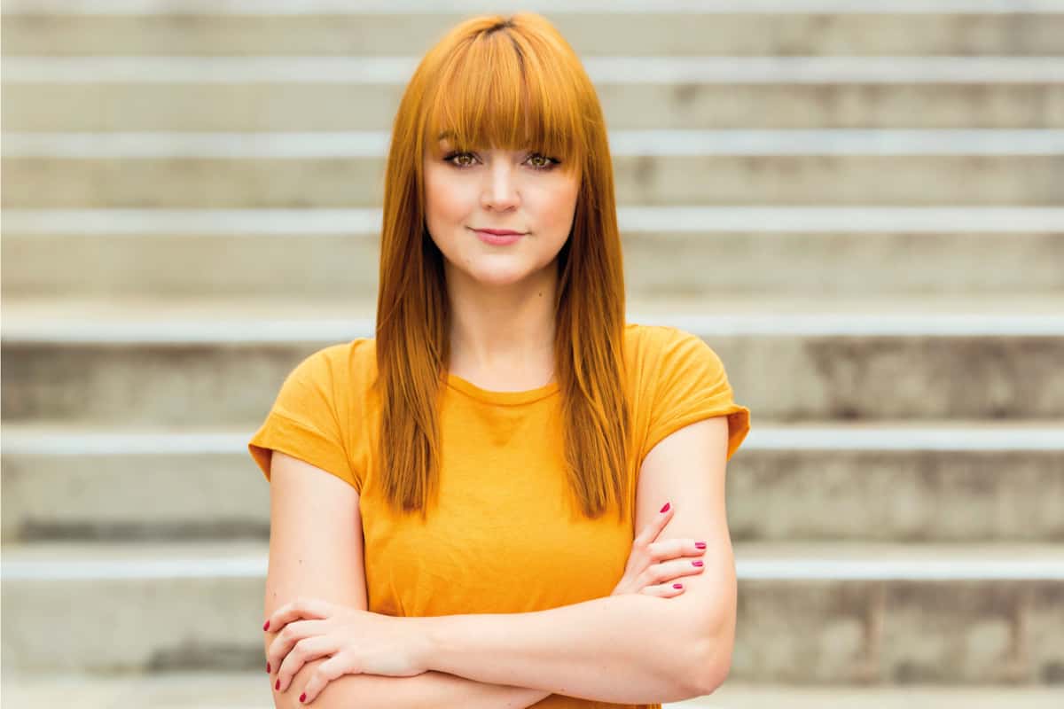 woman in yellow shirt with gorgeous middle part and bangs