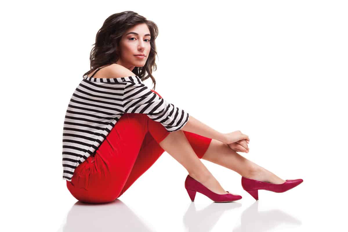 Woman wearing red capris with red heels and a bold striped top