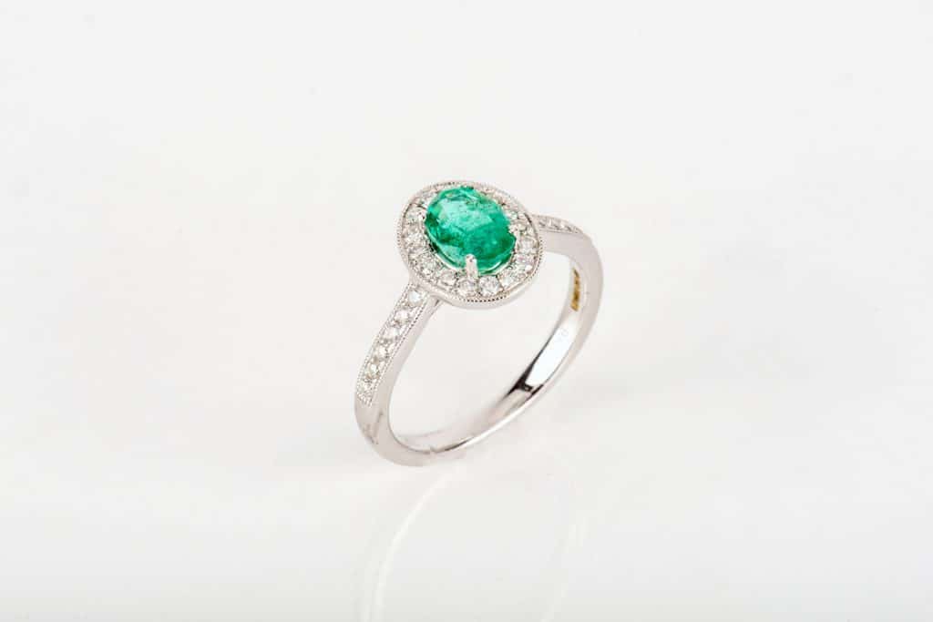 A silver emerald engagement ring on a white background