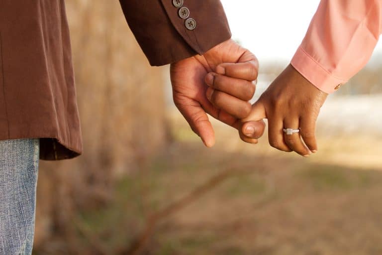 A sweet couple holding hands while walking showing the woman's engagement ring, Can Any Ring Be Used As An Engagement Ring?