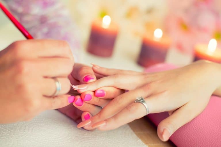 A woman getting her nail polished at a salon, Does Shellac Ruin Your Nails (And Do You Need A Break From Them)