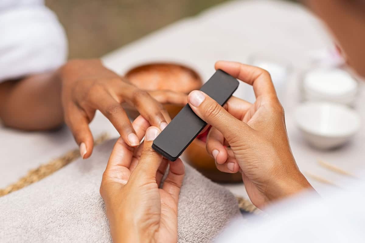 A woman using a buffer on her clients ails