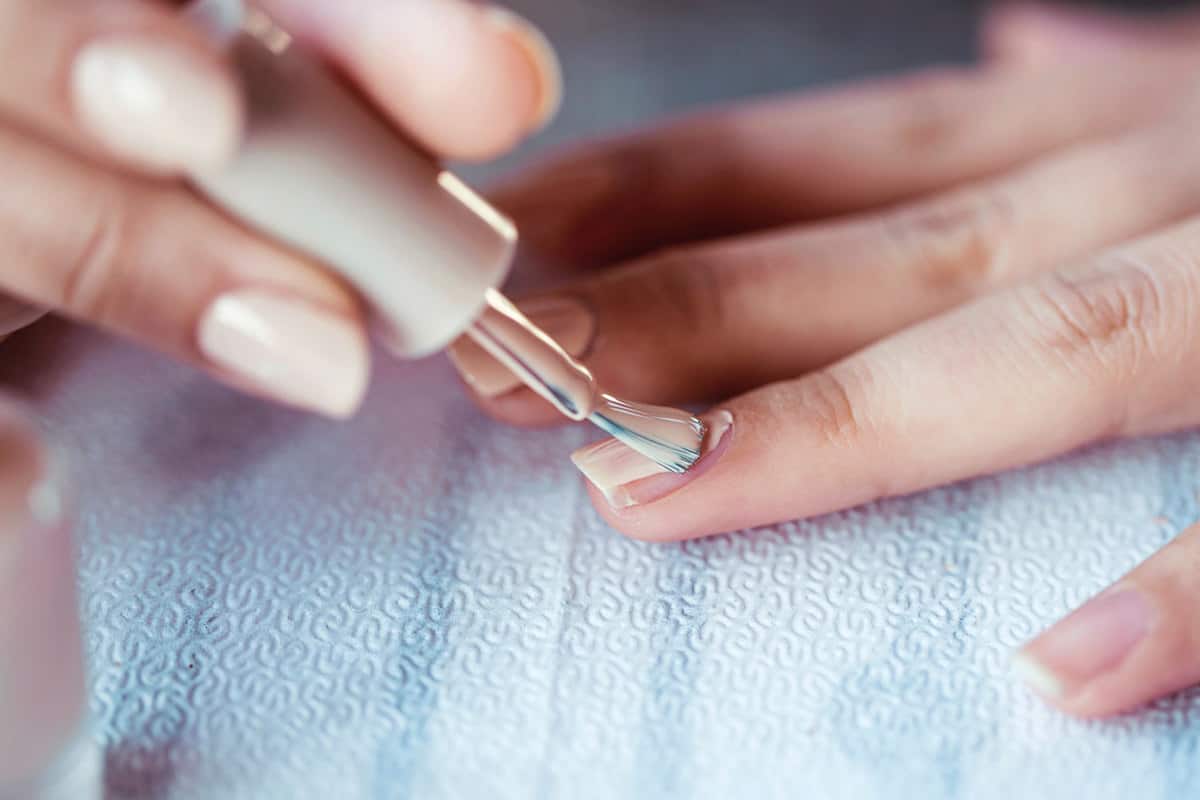 Beautiful manicured woman's nails with cream nail polish