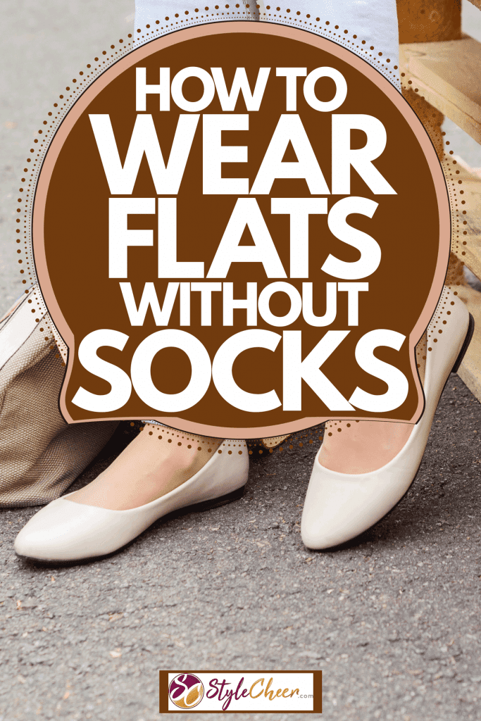 A woman wearing light blue jeans and flats while sitting on palettes, How To Wear Flats Without Socks