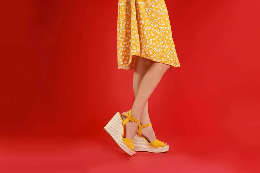 Woman in stylish shoes on red background