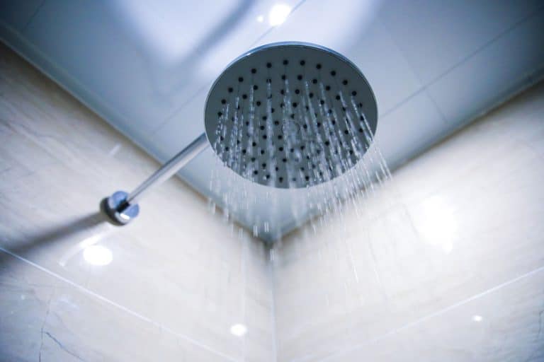 A steam shower head turned on inside a sauna room, How Long Should You Stay In A Steam Shower?