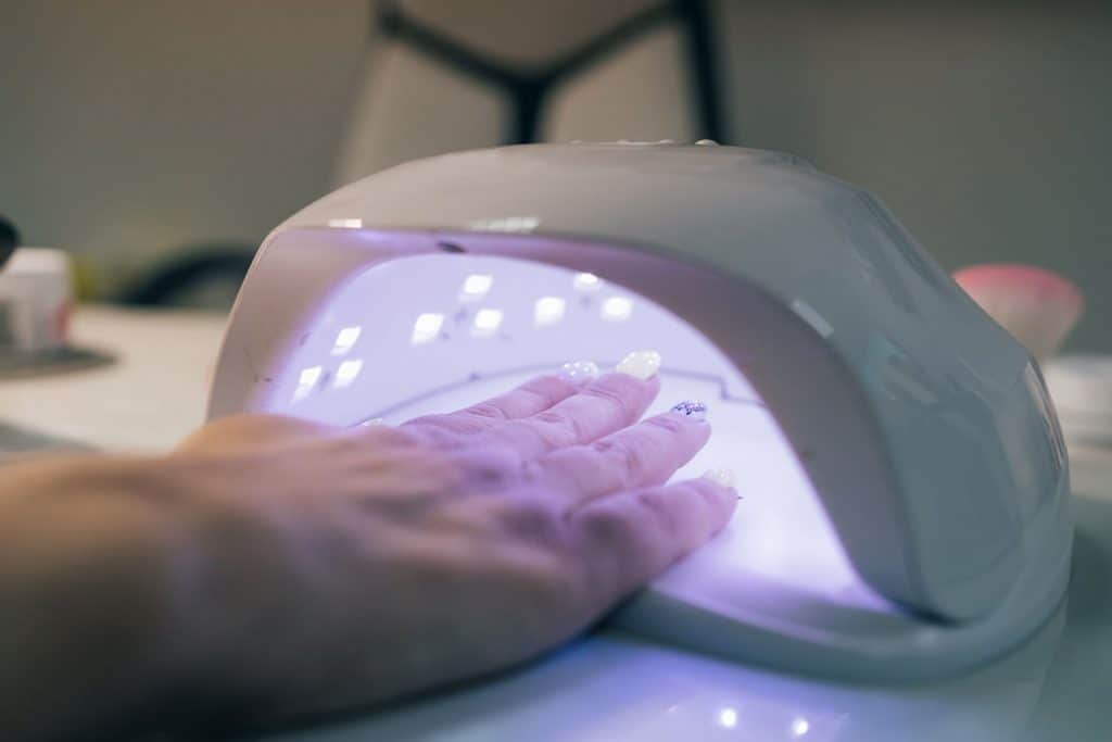 `An acrylic nail polish gel drying under UV light