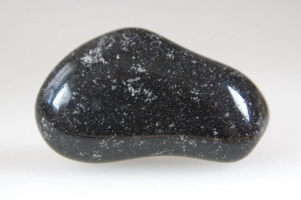 An up close photo of a black onyx stone on a pale gray background