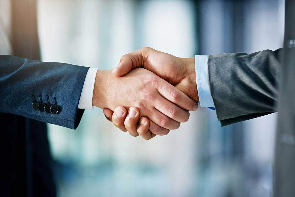 Close up shot of two businessmen shaking hands in an office