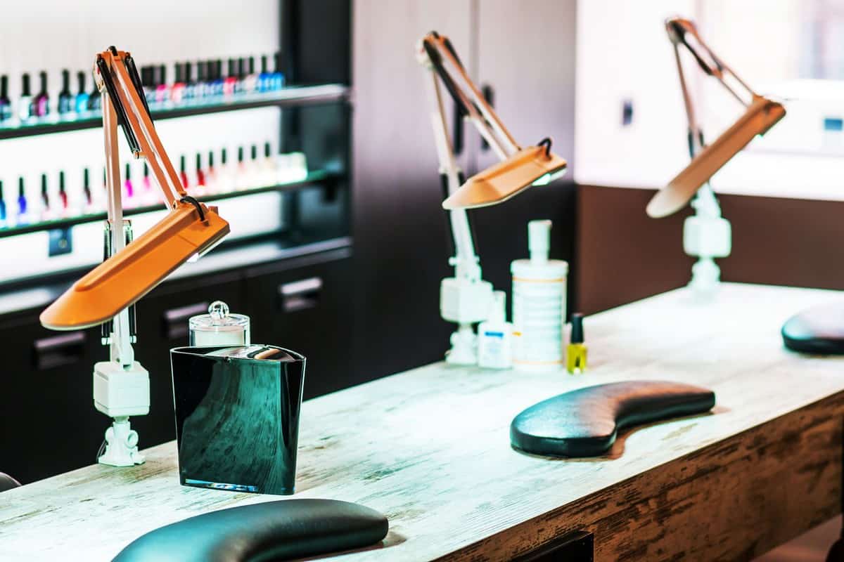 Equipment's inside a nails salon with different nail polish colors on the background