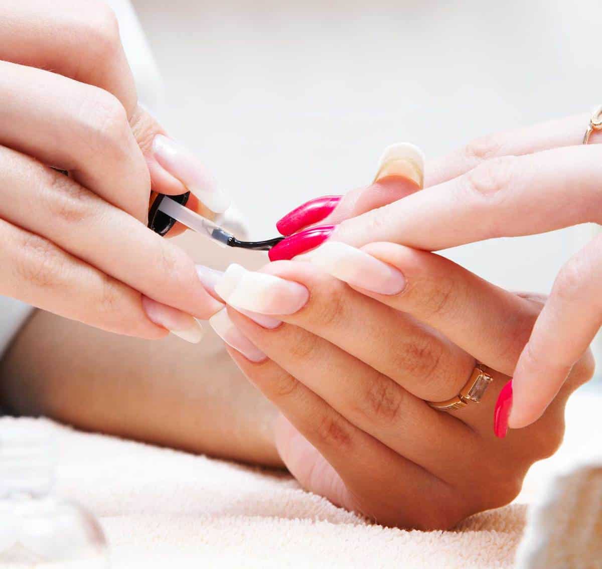 Hand getting red manicure on nails