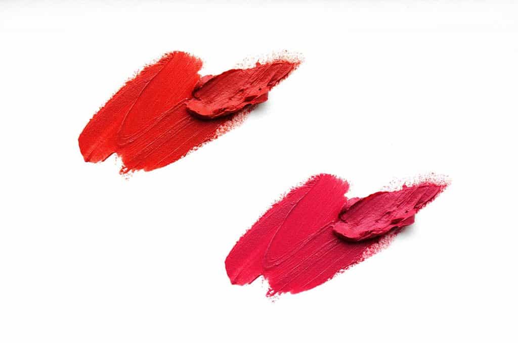Set of smears of red and pink lipsticks close-up isolated on white background