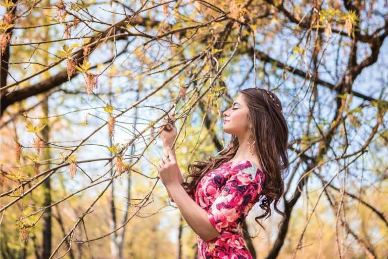 Beautiful girl holding branches of trees. Young woman in a forest park wearing bodycon dress. 6 Of The Best Shoes To Wear With A Bodycon Dress