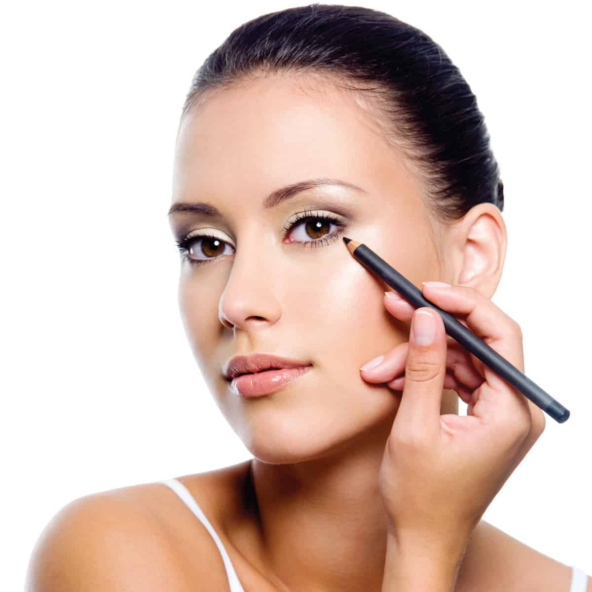 Woman applying eyeliner on eyelid with pencil