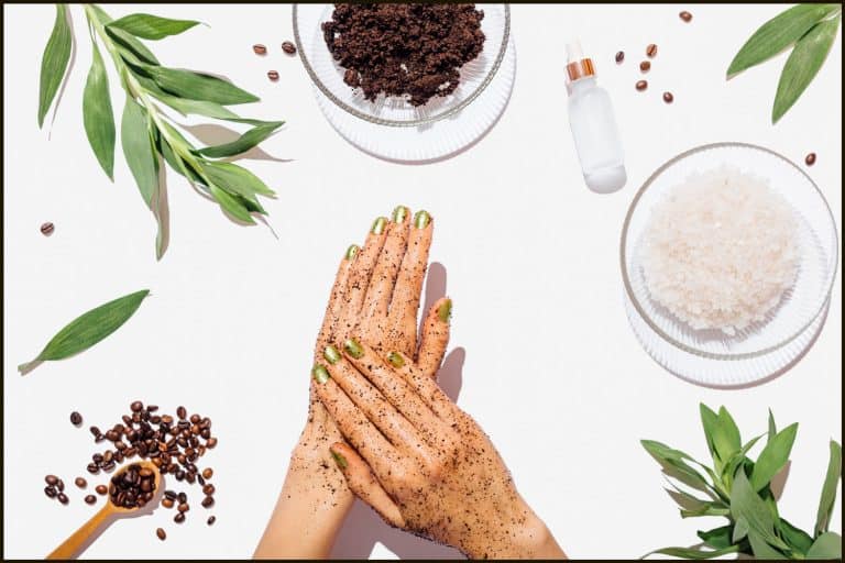 Woman's hands massaging natural homemade coffee scrub with coconut oil on white table next to ingredients, view from above, Does Body Scrub Remove Tan And Make Skin Lighter?